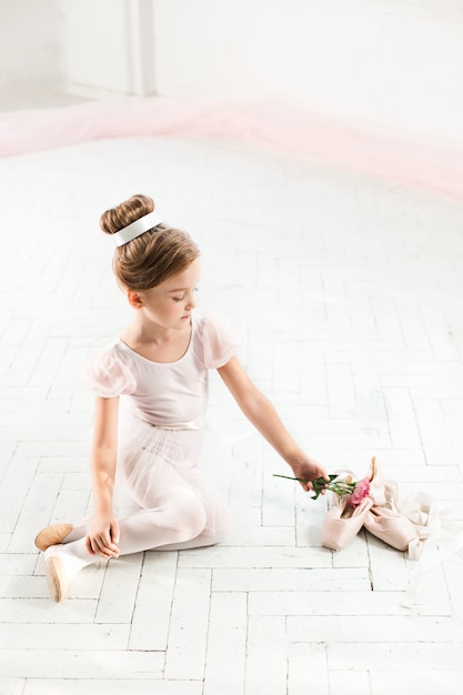 De kleine balerina in witte tutu in de klas op de balletschool