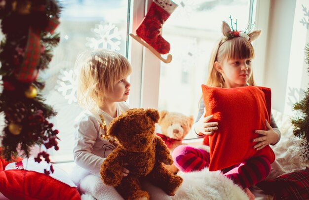 De kleine dochters die op de vensterbank zitten