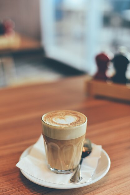 De kop van het glas met koffie en een theelepel