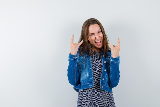 De lachende vrouw toont een rockon-gebaar op een witte achtergrond