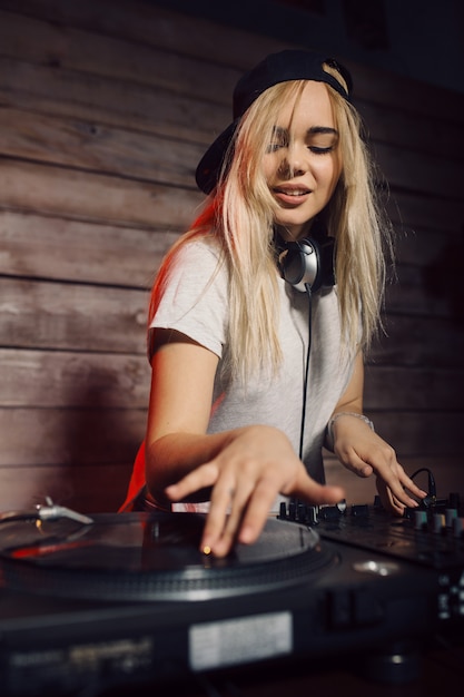 De leuke vrouw die van DJ pret speelmuziek hebben bij clubpartij