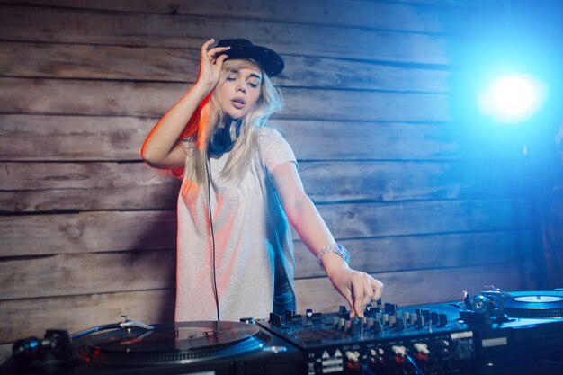 De leuke vrouw die van DJ pret speelmuziek hebben bij clubpartij