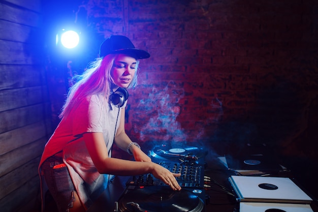De leuke vrouw die van DJ pret speelmuziek hebben bij clubpartij