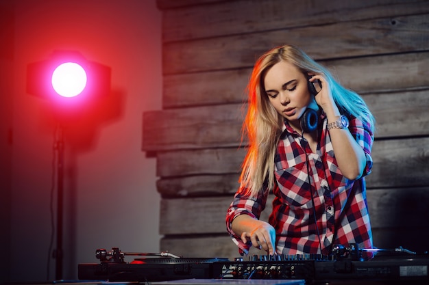 De leuke vrouw die van DJ pret speelmuziek hebben bij clubpartij