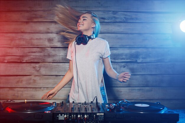 De leuke vrouw die van DJ pret speelmuziek hebben bij clubpartij