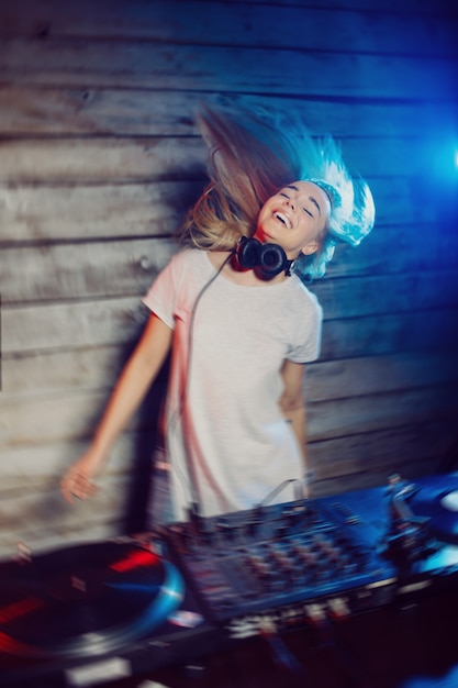 De leuke vrouw die van DJ pret speelmuziek hebben bij clubpartij