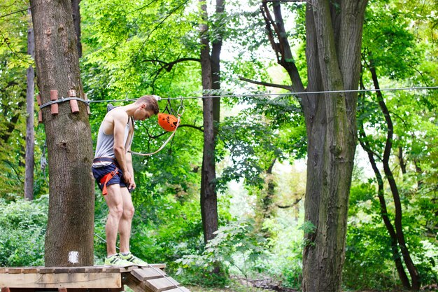 De man bereidt zich op de touwtjes in het park te beklimmen