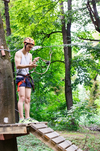 De man bereidt zich op de touwtjes in het park te beklimmen