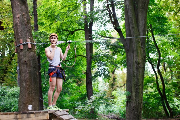 De man bereidt zich op de touwtjes in het park te beklimmen