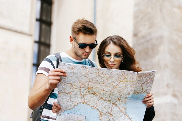 De man en de vrouw bekijken de kaart die zich in oude stad bevindt