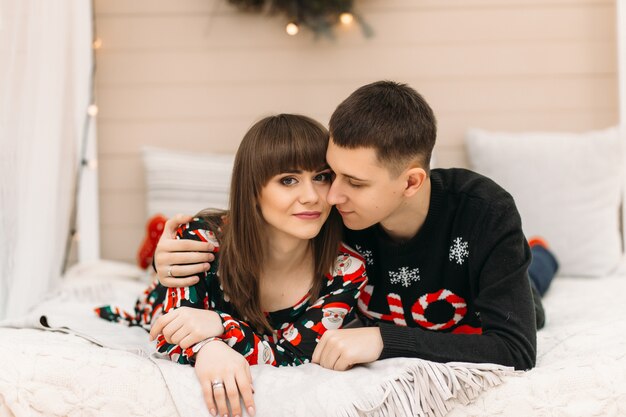 De man en de vrouw rusten op het bed in een ruimte gekleed voor de wintervakantie