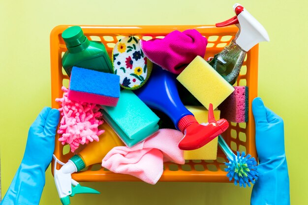 De mand van de de persoonsholding van de close-up met schoonmakende producten