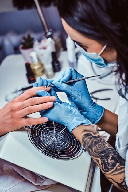 De manicure doet de procedure om de nagelriemen te trimmen en te verwijderen in de schoonheidssalon