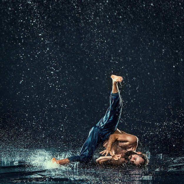 De mannelijke breakdancer in water.