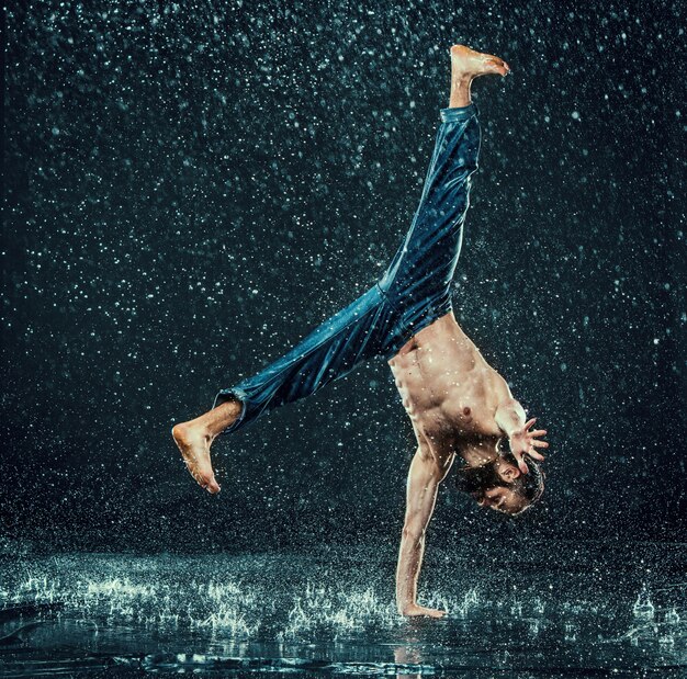 De mannelijke breakdancer in water.