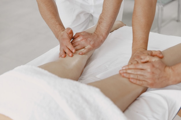 De massage met vier handen. Concept van gezondheidszorg en vrouwelijke schoonheid. Twee masseuses maken een dubbele massage van een meisje. Vrouw in een kuuroordsalon.