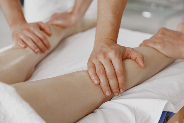 De massage met vier handen. Concept van gezondheidszorg en vrouwelijke schoonheid. Twee masseuses maken een dubbele massage van een meisje. Vrouw in een kuuroordsalon.