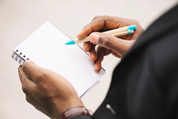 De mens die van het gewas in leeg notitieboekje schrijft