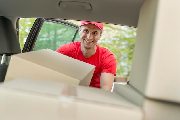 Gratis foto de mens die van smiley pakket in auto zet