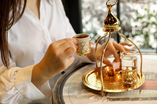 De mens gaat Turkse koffie in traditioneel de suiker zijaanzicht van het schotelwater drinken