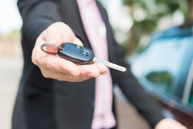 De mens geeft een autosleutel aan iemand