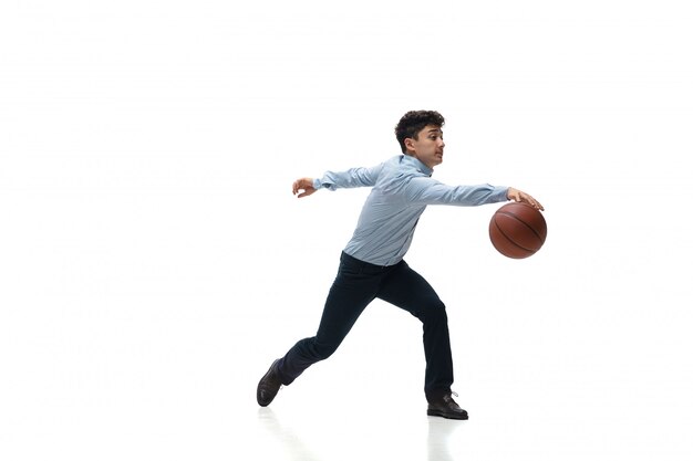 De mens in bureau kleedt het spelen van basketbal op witte ruimte. Ongewone look voor zakenman in beweging, actie. Sport, gezonde levensstijl.