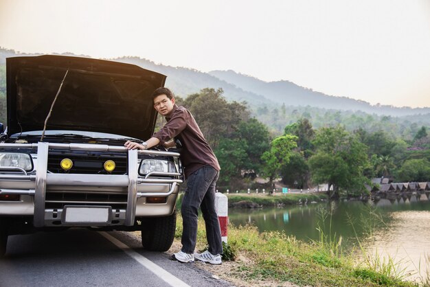 De mens probeert om een motor van een autoprobleem op een lokale weg Chiang MAI Thailand te bevestigen