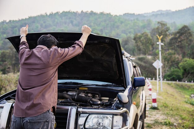 De mens probeert om een motor van een autoprobleem op een lokale weg Chiang MAI Thailand te bevestigen