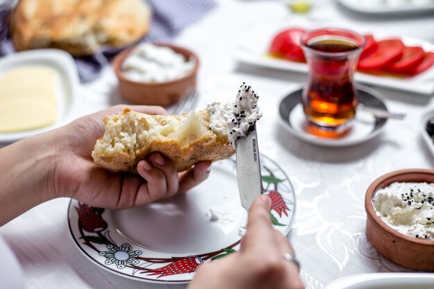 De mens smeert shor vergist melkproduct op het brood zijaanzicht