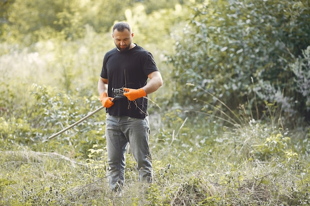 De mens verzamelt bladeren en maakt het park schoon