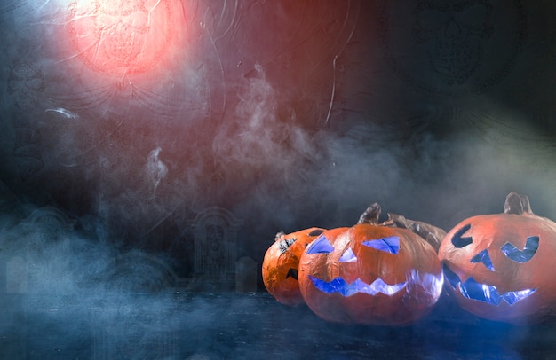 Gratis foto de met de hand gemaakte pompoenen van halloween verlichten binnen het liggen aan kant met rook