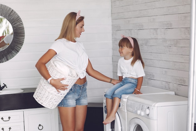 De moeder en de dochter in een badkamers wassen dichtbij mashine