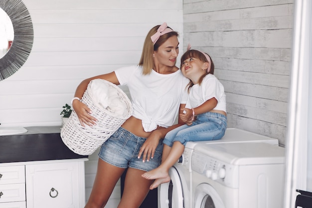 De moeder en de dochter in een badkamers wassen dichtbij mashine