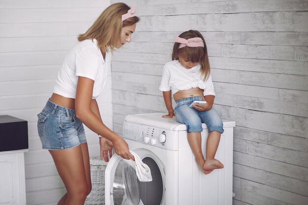 De moeder en de dochter in een badkamers wassen dichtbij mashine