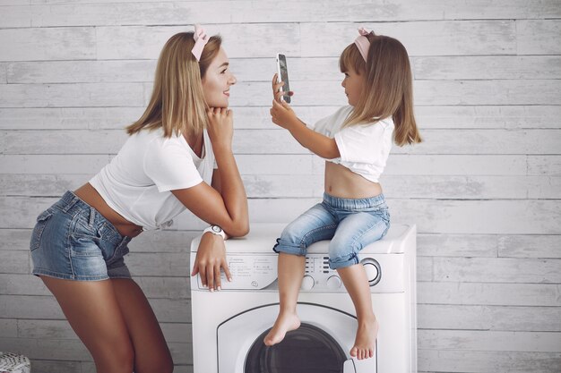 De moeder en de dochter in een badkamers wassen dichtbij mashine