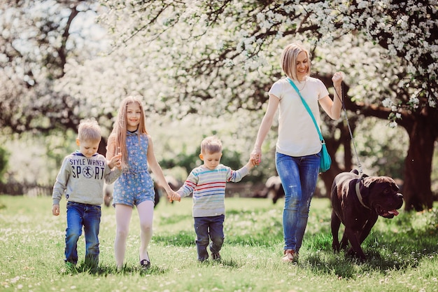 De moeder, kinderen en hond wandelen langs park