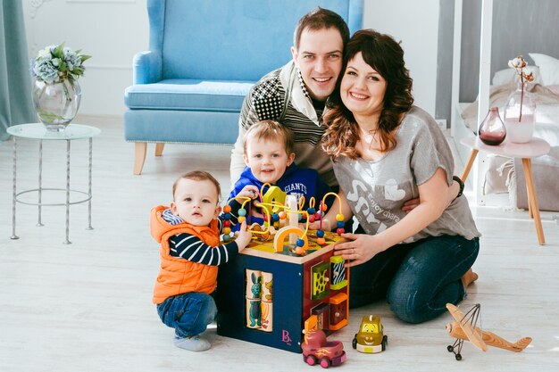 De moeder, vader en zonen spelen met speelgoed