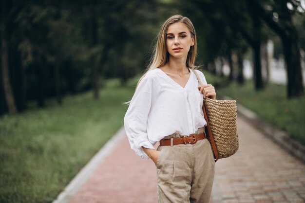 De mooie blondevrouw in park die de zomer draagt ziet eruit