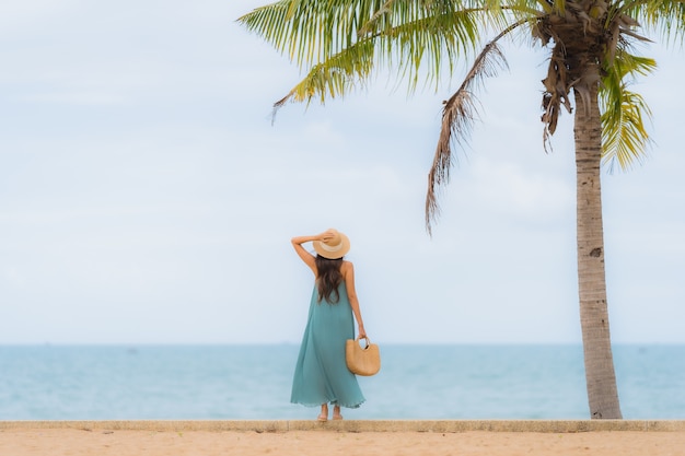 De mooie gelukkige glimlach van portret jonge Aziatische vrouwen ontspant rond strand overzeese oceaan