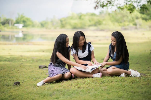 De mooie groep van studentenmeisjes bereidt zich voor op het examen op het park