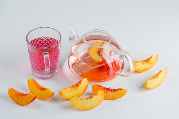 De nectarineplakken met de zomer drinken hoge hoekmening over een witte oppervlakte