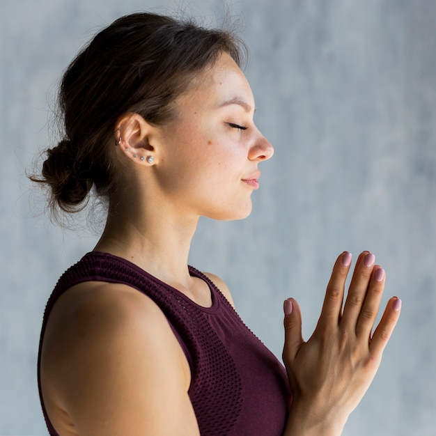 Gratis foto de ontspannen vrouwenholding dient een namaste yoga in stelt