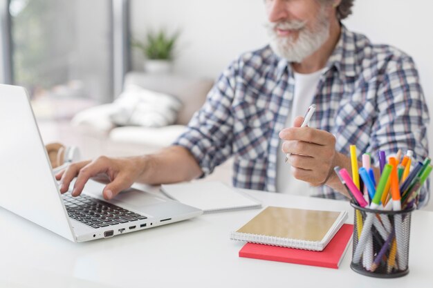 De pen van de leraarsholding die laptop met behulp van