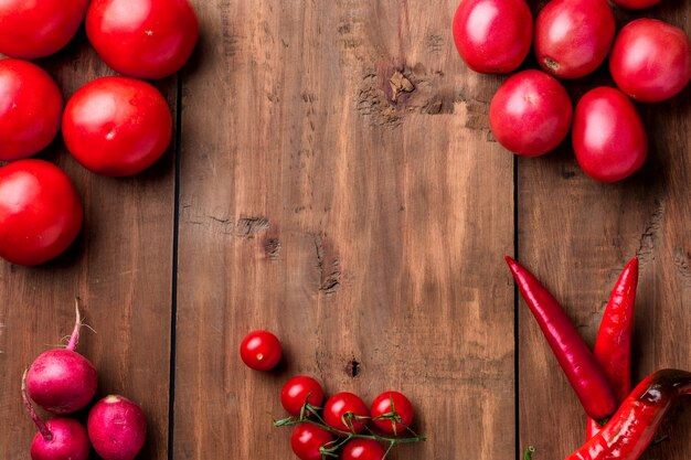 De rode groenten op houten tafel achtergrond