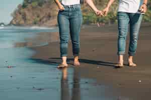 Gratis foto de romantische hand van de paarholding en het lopen op strand