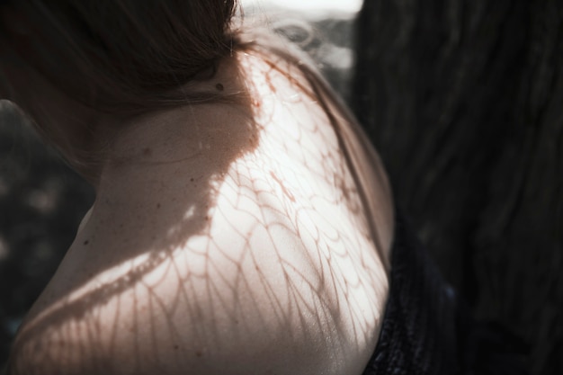 De schouders van de jonge vrouw in bos