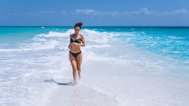 De sexy vrouw zwemt binnen slijtage die zich in de oceaan bevindt