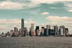 Gratis foto de skyline van de binnenstad van manhattan met stedelijke wolkenkrabbers over de rivier.