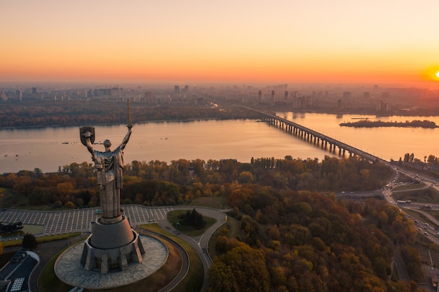 De skyline van kiev over prachtige vurige zonsondergang, oekraïne. monument moederland.