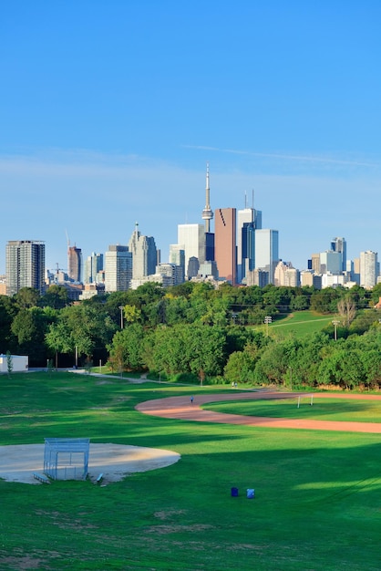 De skyline van Toronto over park met stedelijke gebouwen en blauwe lucht